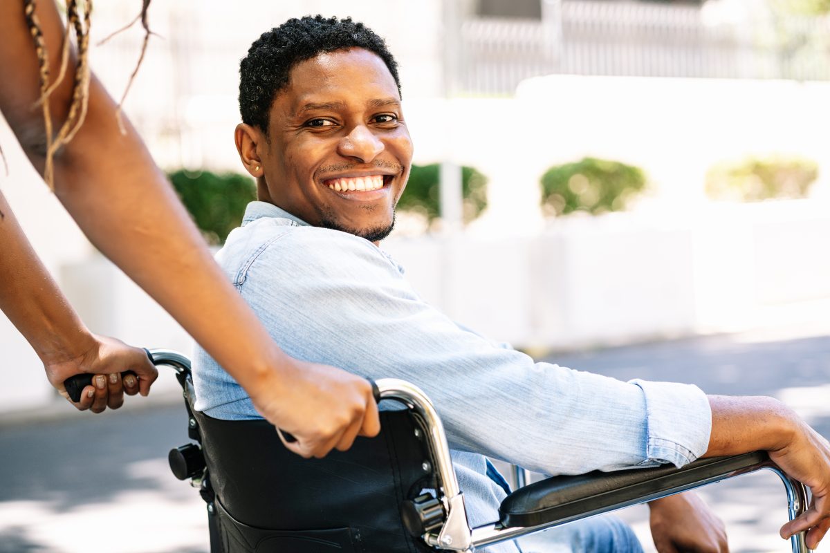 african-american-man-wheelchair-smiling-looking-camera-while-his-girlfriend-pushing-him-1200x800.jpg